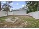 Large backyard with a white fence and an inground cinder block fire pit under a mix of sun and shade at 1094 Lolita St, Orange City, FL 32763