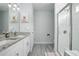 Bright bathroom featuring a granite vanity, dual sinks, and a glass-enclosed shower with white subway tile at 1094 Lolita St, Orange City, FL 32763