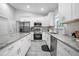 Modern kitchen with white cabinetry, stainless steel appliances, and granite countertops at 1094 Lolita St, Orange City, FL 32763
