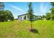 This home features a lovely backyard with a tree and lush green grass, great for outdoor enjoyment at 1161 Kenway Ave, Deltona, FL 32738