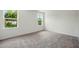 Cozy bedroom featuring two bright windows and neutral carpet at 1161 Kenway Ave, Deltona, FL 32738