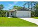 Well-maintained single-story home featuring an attached two-car garage and lush green lawn at 1161 Kenway Ave, Deltona, FL 32738