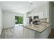 Bright kitchen featuring stainless appliances, granite countertops, and access to the lanai at 1161 Kenway Ave, Deltona, FL 32738