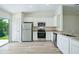 Open concept kitchen with stainless appliances, granite countertops, and sliding glass doors at 1161 Kenway Ave, Deltona, FL 32738