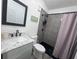 Modern bathroom featuring gray tiled walk-in shower with black fixtures and granite vanity at 1215 N Boston Ave, Deland, FL 32724