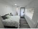 Bright bedroom features light wood-look floors, a patterned quilt, and a washer and dryer in the closet at 1215 N Boston Ave, Deland, FL 32724