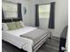 Bright bedroom with gray wood floors, two windows and stylish decor at 1215 N Boston Ave, Deland, FL 32724