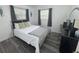 Bright bedroom with gray wood floors, two windows and stylish decor at 1215 N Boston Ave, Deland, FL 32724