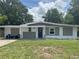 Charming one-story home with a manicured lawn and inviting front porch seating at 1215 N Boston Ave, Deland, FL 32724