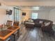 Comfortable living room featuring a brown sectional sofa, wood floors, and a view to the dining area at 1215 N Boston Ave, Deland, FL 32724