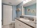 Bathroom with blue walls, tile floors, single sink vanity with granite countertop, and a toilet next to a closet at 122 Cedar Dunes Dr, New Smyrna Beach, FL 32169