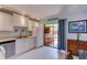 Bright kitchen with white cabinetry, tile flooring, and access to an outdoor patio with bar seating at 122 Cedar Dunes Dr, New Smyrna Beach, FL 32169