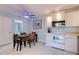 A well-lit kitchen and dining area featuring white cabinetry, tile floors and modern appliances at 122 Cedar Dunes Dr, New Smyrna Beach, FL 32169