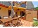 Private outdoor patio features a dining set, shade umbrella, and a Tiki bar, perfect for entertaining at 122 Cedar Dunes Dr, New Smyrna Beach, FL 32169