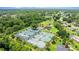 Overhead view of tennis and pickleball courts surrounded by lush greenery and community buildings at 123 Wood Ibis Ct, Daytona Beach, FL 32119