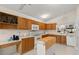 Well-lit kitchen with wood cabinetry, a functional island, white appliances, and a bright, inviting atmosphere at 123 Wood Ibis Ct, Daytona Beach, FL 32119