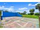 Bright blue racquetball court with mature palms against a bright blue sky at 123 Wood Ibis Ct, Daytona Beach, FL 32119
