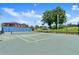 Well-kept tennis court with lights, adjacent to the clubhouse and surrounded by trees at 123 Wood Ibis Ct, Daytona Beach, FL 32119