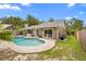 Backyard featuring an in-ground pool, covered outdoor kitchen, and well-maintained landscaping at 1261 Burning Tree Ln, Winter Park, FL 32792