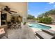 Backyard with pool, outdoor kitchen, bar seating, and lounge chairs at 1261 Burning Tree Ln, Winter Park, FL 32792