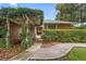 Charming front entrance with lush landscaping and covered walkway to the front door at 1261 Burning Tree Ln, Winter Park, FL 32792