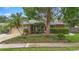 Inviting single-story home featuring a well-manicured front yard with mature trees at 1261 Burning Tree Ln, Winter Park, FL 32792