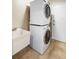 Convenient laundry room with stacked washer and dryer and utility sink at 1261 Burning Tree Ln, Winter Park, FL 32792