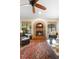 Inviting living room with brick fireplace, ceiling fan, and views of the pool at 1261 Burning Tree Ln, Winter Park, FL 32792