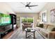 Comfortable living room features stylish seating, ceiling fan, a large area rug and sliding glass door to the pool at 1261 Burning Tree Ln, Winter Park, FL 32792