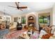 Open living room with brick fireplace, ceiling fan, and access to dining area at 1261 Burning Tree Ln, Winter Park, FL 32792