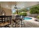 Comfortable bar stool seating at the outdoor kitchen bar with a view of the pool at 1261 Burning Tree Ln, Winter Park, FL 32792
