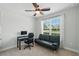 Bedroom with neutral walls has a black futon, an office desk, and a ceiling fan at 1314 Lake Baton Dr, Deltona, FL 32725
