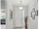 Bright entryway featuring a white door, transom window, elegant lighting, and stylish décor at 1314 Lake Baton Dr, Deltona, FL 32725
