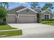 Attractive home with a three-car garage and stone detailing, complemented by green landscaping at 1314 Lake Baton Dr, Deltona, FL 32725
