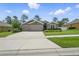 Attractive home boasting a three-car garage, stone veneer, and meticulously maintained landscaping at 1314 Lake Baton Dr, Deltona, FL 32725