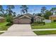 Charming single-story home with a three-car garage, stone accents, and manicured lawn at 1314 Lake Baton Dr, Deltona, FL 32725