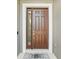 A traditional brown front door with sidelight and welcome mat, inviting entrance to the home at 1314 Lake Baton Dr, Deltona, FL 32725
