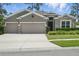 Charming home with a well-manicured lawn, stone accents, and a three-car garage at 1314 Lake Baton Dr, Deltona, FL 32725