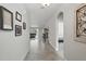 Spacious hallway with gray tile flooring, framed artwork, and views into the living areas at 1314 Lake Baton Dr, Deltona, FL 32725