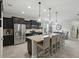 An open kitchen features a large island with pendant lights, stainless appliances, and black cabinets at 1314 Lake Baton Dr, Deltona, FL 32725
