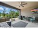 A covered patio with a ceiling fan, a table, and chairs, with a view of the lake at 1314 Lake Baton Dr, Deltona, FL 32725