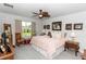 Primary bedroom with a queen bed, ceiling fan and view of the green landscaped yard at 1323 Donatello Ln, Winter Haven, FL 33884