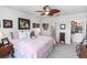 View of the spacious bedroom with a ceiling fan, a bed with a pink blanket, and pictures on the wall at 1323 Donatello Ln, Winter Haven, FL 33884