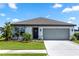 Lovely single-story home featuring a well-manicured lawn, beautiful landscaping, and a spacious two-car garage at 1323 Donatello Ln, Winter Haven, FL 33884