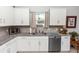 Modern kitchen featuring white cabinets, stainless steel appliances, granite countertops, and a window view at 1323 Donatello Ln, Winter Haven, FL 33884