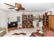 Spacious living room featuring a ceiling fan, decorative bookcases, and ample natural light at 1323 Donatello Ln, Winter Haven, FL 33884