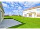 Spacious backyard with a large grass area, a patio, and a two-story house in the background at 136 Columbia Dr, Kissimmee, FL 34759