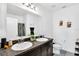 Well-lit bathroom featuring double sinks, granite countertop, and a framed mirror at 136 Columbia Dr, Kissimmee, FL 34759