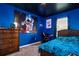 Themed bedroom featuring bright blue walls and ceiling, a large poster, and study area at 136 Columbia Dr, Kissimmee, FL 34759