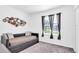 Bright bedroom with a modern sofa bed, neutral tones, and a decorative circle wall art at 136 Columbia Dr, Kissimmee, FL 34759